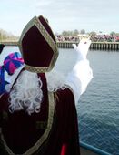 Sinterklaas zwaait vanaf zijn boot.