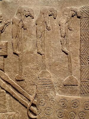 Detail van een Assyrisch reliëf uit de periode 720-714 voor Christus waarop te zien is hoe mensen gespiest worden tijdens de plundering van een stad. Mary Harrsch, CC BY-SA 4.0 via Wikimedia Commons