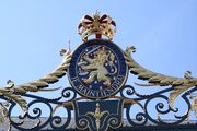 Wapen van het Koninkrijk der Nederlanden, met de lijfspreuk Je maintiendrai, als onderdeel van het hek aan de voorzijde van het paleis