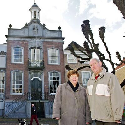 Wethouder Lida Verschuren en stadsgids Jos de Waard met op de de achtergrond het oude stadhuis aan de markt in Geertruidenberg.