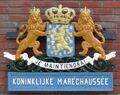 Wapen van de Koninklijke Marechaussee afkomstig van het oude stationsgebouw van Schiphol en thans in het Aviodome. Staatswapen van 1815/´16, in de titel de toevoeging „Koninklijke”.